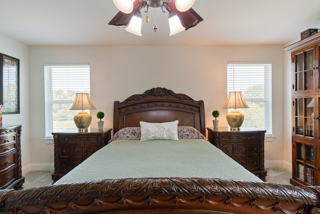 carpeted bedroom with ceiling fan and multiple windows