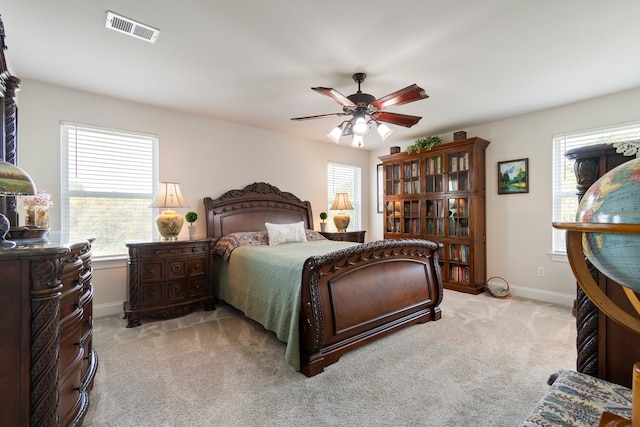 carpeted bedroom with ceiling fan and multiple windows