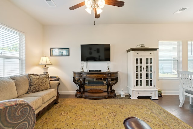 living room with a wealth of natural light, ceiling fan, and dark hardwood / wood-style floors