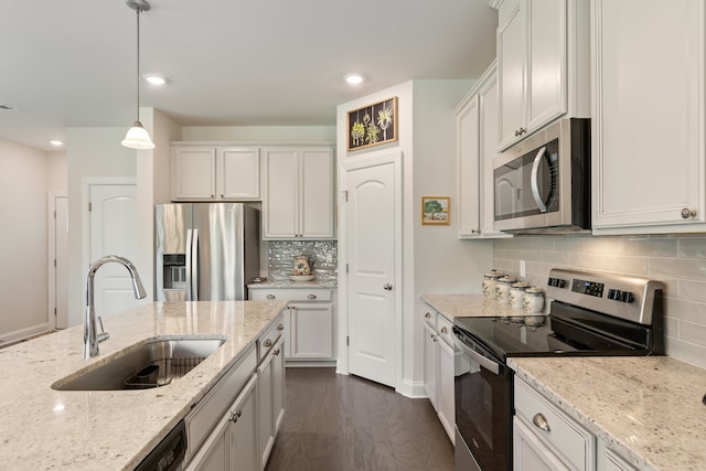 kitchen with dark wood-type flooring, stainless steel appliances, white cabinets, and hanging light fixtures