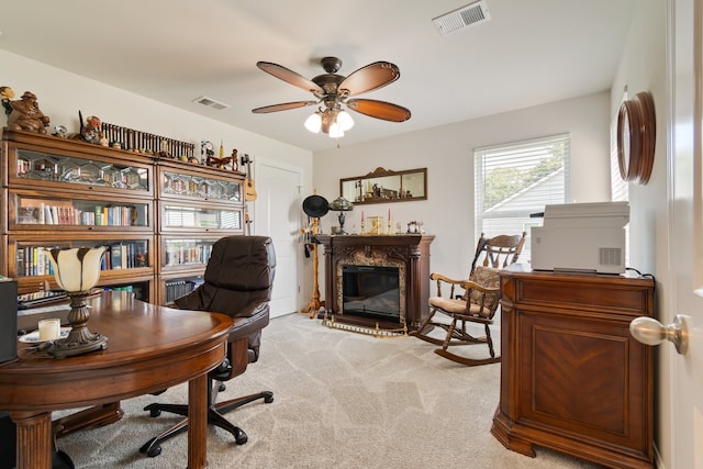 carpeted office with a high end fireplace and ceiling fan