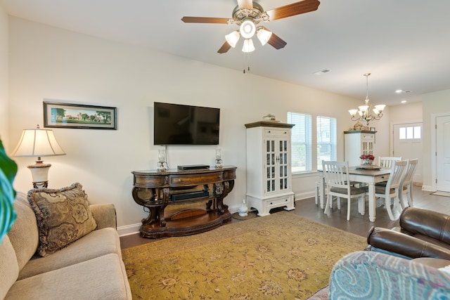 living room with ceiling fan with notable chandelier and wood-type flooring