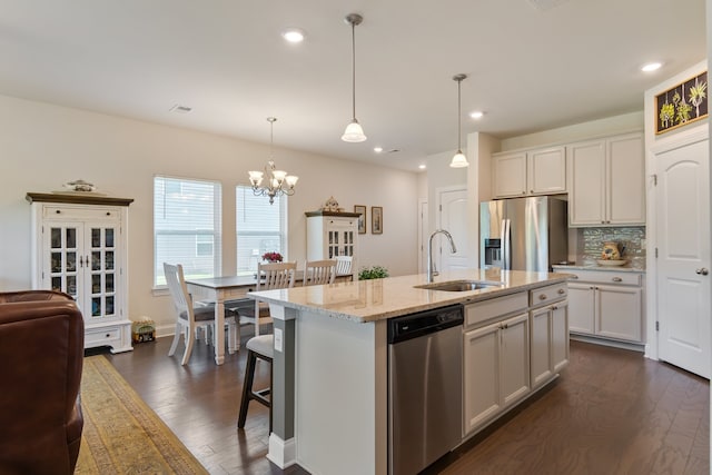 kitchen with a center island with sink, dark wood-type flooring, sink, and appliances with stainless steel finishes