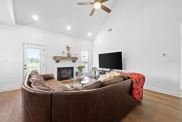 living room featuring a large fireplace, ceiling fan, high vaulted ceiling, and hardwood / wood-style flooring