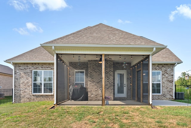 back of property featuring a patio area, a lawn, and ceiling fan