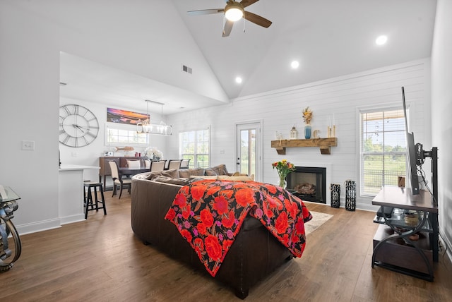 living room featuring ceiling fan, hardwood / wood-style floors, high vaulted ceiling, and a fireplace