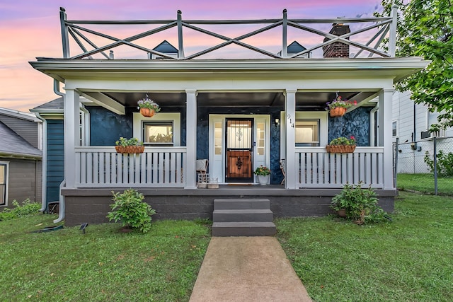 view of front of property with a lawn and a porch