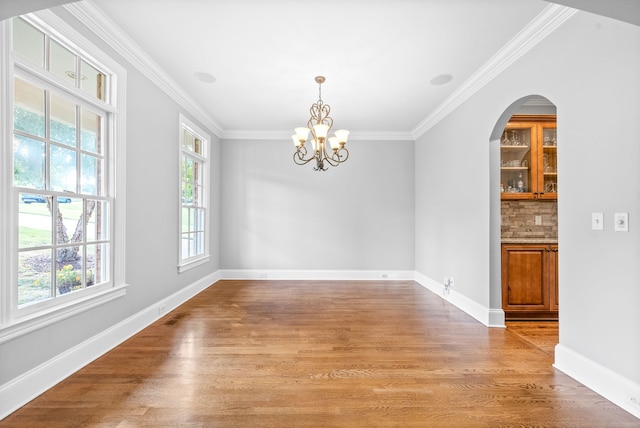 unfurnished dining area with visible vents, baseboards, light wood-style flooring, and crown molding