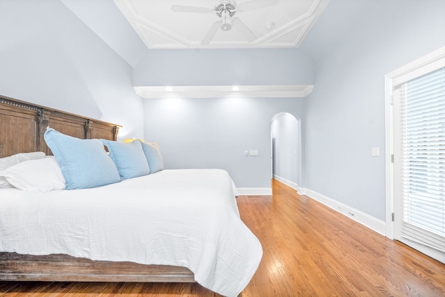 bedroom featuring ceiling fan, baseboards, arched walkways, and light wood-style flooring