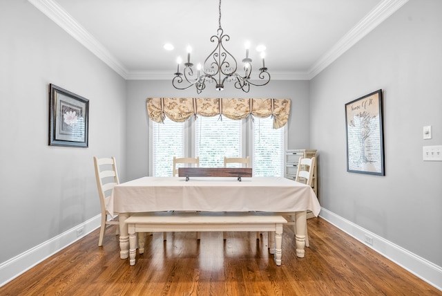 dining space featuring baseboards, wood finished floors, and crown molding