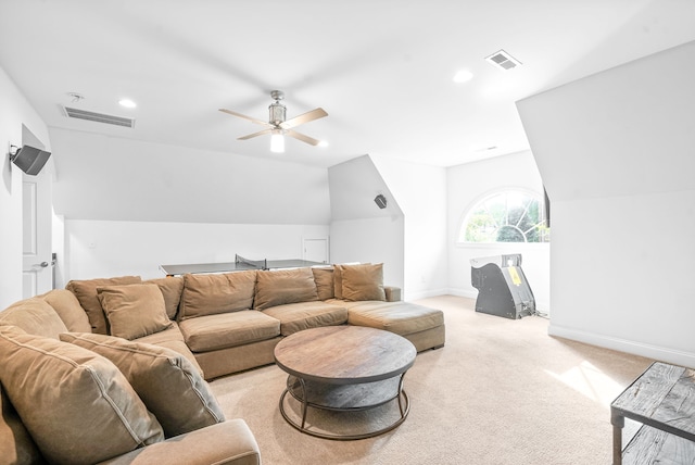 living area with visible vents, light colored carpet, baseboards, and vaulted ceiling