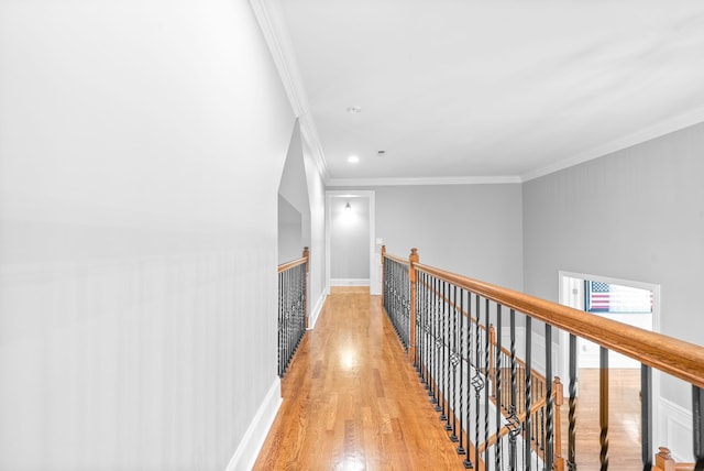 hall featuring baseboards, an upstairs landing, ornamental molding, and light wood finished floors