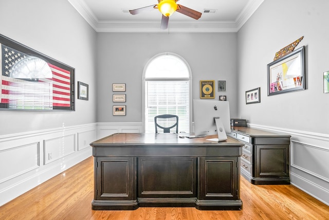 office with wainscoting, light wood-style flooring, ceiling fan, and ornamental molding