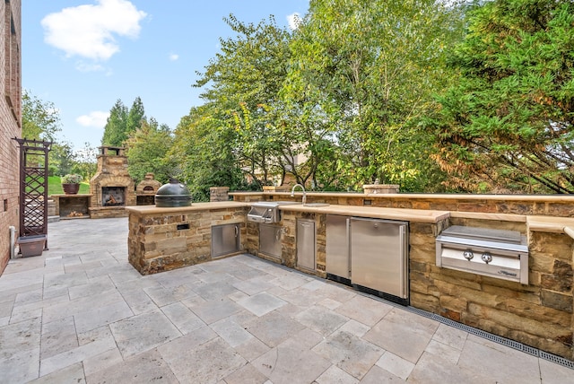 view of patio with an outdoor kitchen and an outdoor stone fireplace