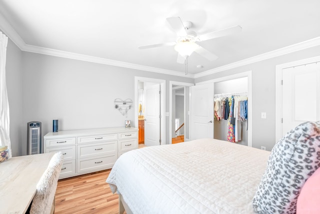 bedroom featuring a ceiling fan, ensuite bath, light wood-style floors, a closet, and crown molding