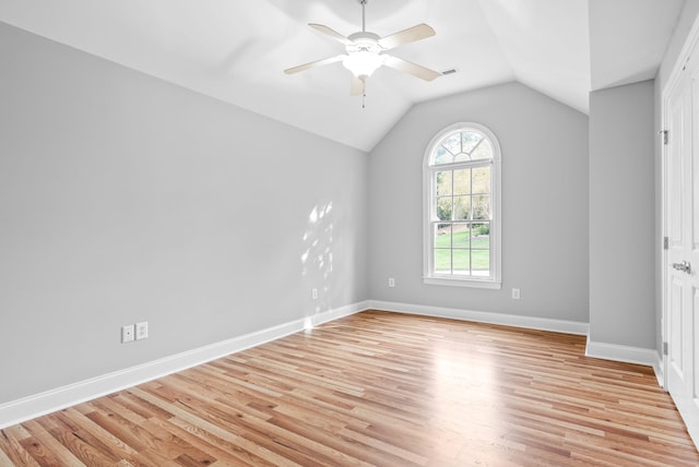 unfurnished room featuring visible vents, baseboards, lofted ceiling, light wood-style floors, and a ceiling fan