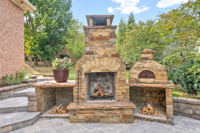 view of patio featuring an outdoor stone fireplace