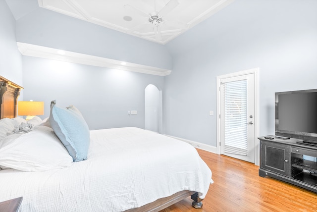 bedroom featuring lofted ceiling, a ceiling fan, wood finished floors, arched walkways, and baseboards