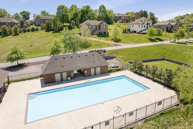 community pool featuring a patio area, fence, and a residential view