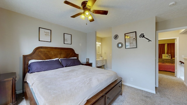 carpeted bedroom with a textured ceiling, connected bathroom, and ceiling fan