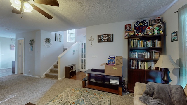 living room featuring a textured ceiling, ceiling fan, and carpet floors