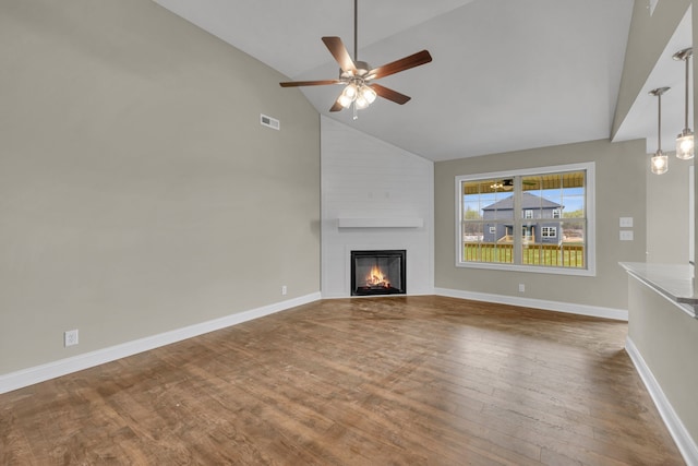 unfurnished living room with wood-type flooring, a large fireplace, high vaulted ceiling, and ceiling fan