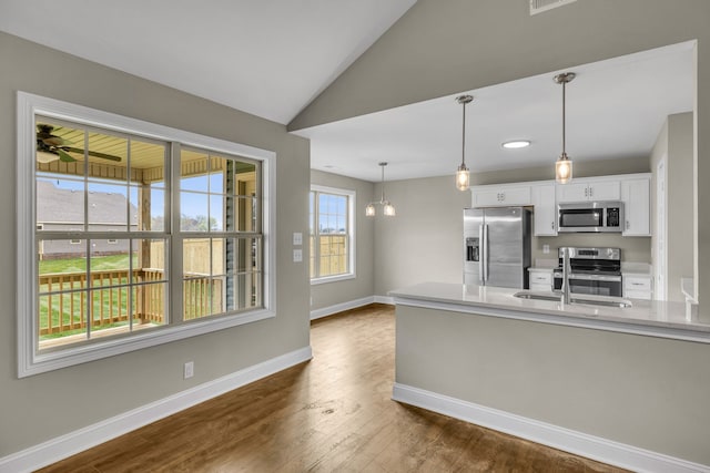 kitchen featuring dark wood-type flooring, an inviting chandelier, sink, white cabinetry, and stainless steel appliances