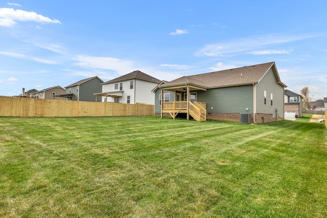 back of property with central AC unit and a lawn