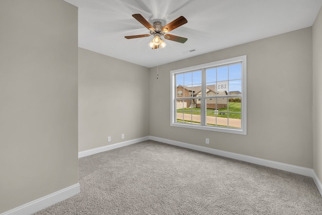 carpeted spare room featuring ceiling fan