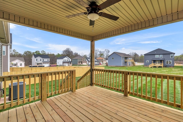 wooden deck featuring a lawn, ceiling fan, and cooling unit