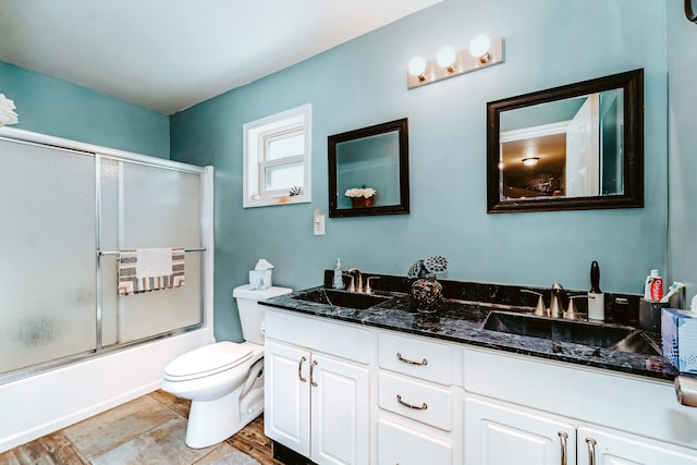 full bathroom with shower / bath combination with glass door, toilet, and vanity