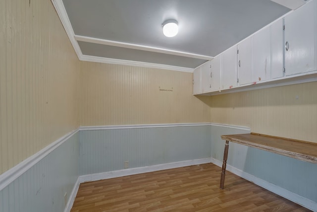 empty room with light hardwood / wood-style flooring and wood walls