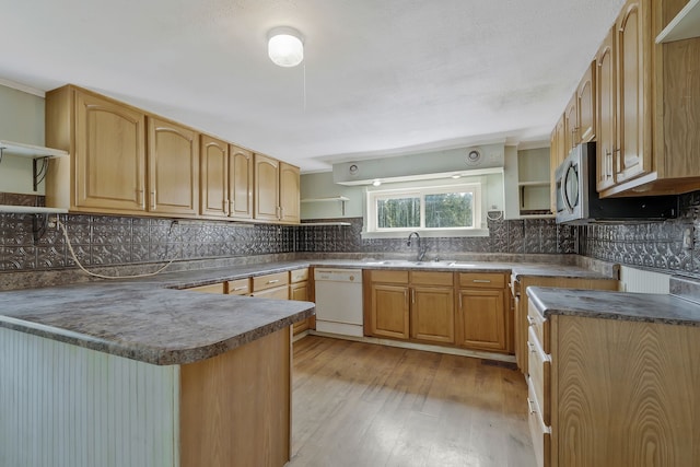 kitchen with light hardwood / wood-style flooring, kitchen peninsula, white dishwasher, sink, and decorative backsplash