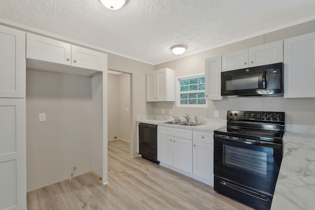 kitchen featuring white cabinets, light wood-type flooring, light stone counters, sink, and black appliances