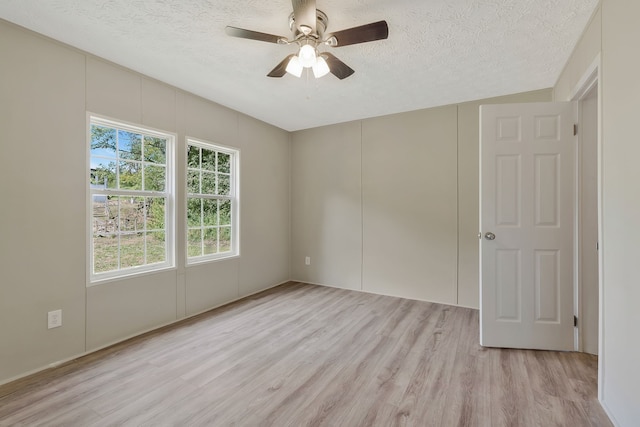 unfurnished room with a textured ceiling, light hardwood / wood-style flooring, and ceiling fan