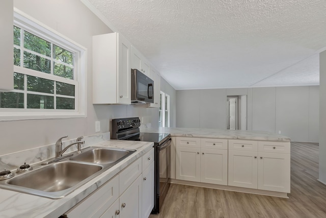 kitchen with black appliances, light hardwood / wood-style flooring, kitchen peninsula, and white cabinets