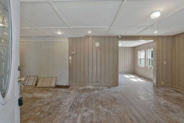 unfurnished room with wood-type flooring and wooden walls