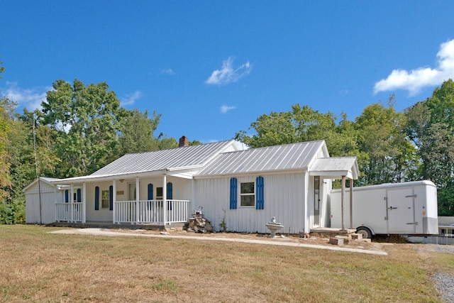 view of front of property with a porch, a storage shed, and a front yard