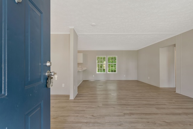 foyer entrance with light hardwood / wood-style floors and a textured ceiling