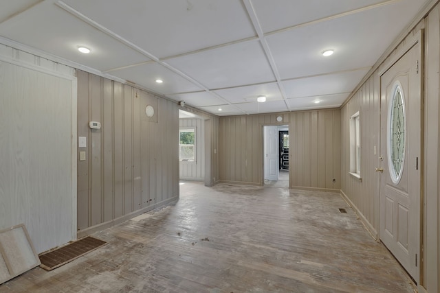 entrance foyer with wooden walls and light hardwood / wood-style flooring