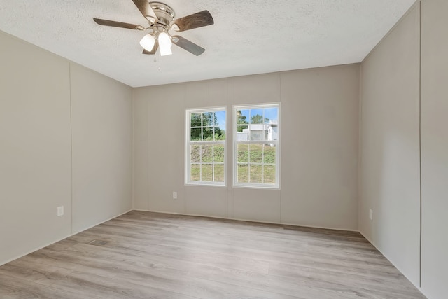 spare room featuring ceiling fan, light hardwood / wood-style floors, and a textured ceiling