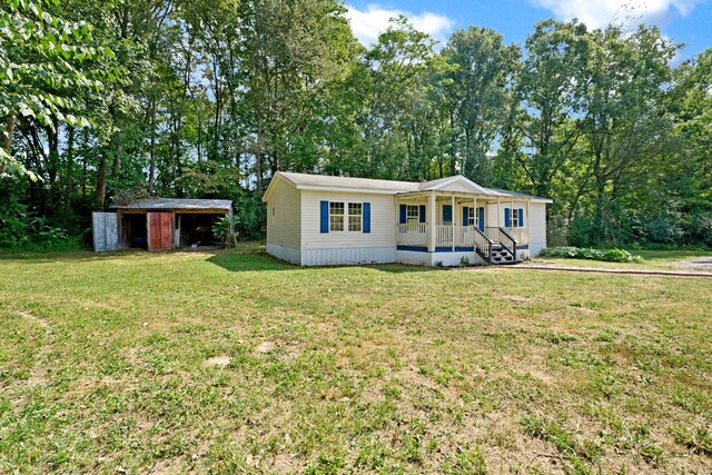 view of front of home with a storage shed, a front yard, and a porch