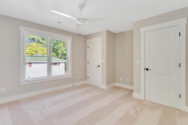 unfurnished bedroom featuring light carpet and ceiling fan