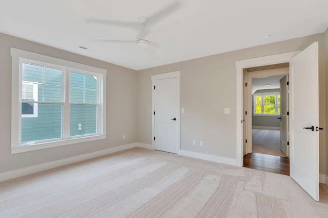 unfurnished bedroom with light carpet and ceiling fan