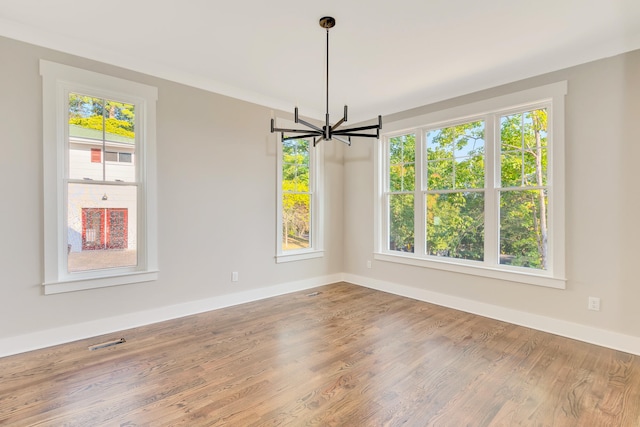 unfurnished dining area featuring a notable chandelier and wood-type flooring