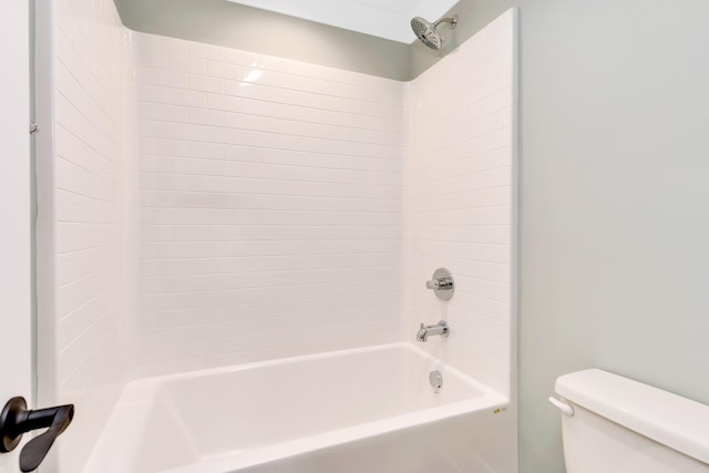 bathroom with toilet and tiled shower / bath combo