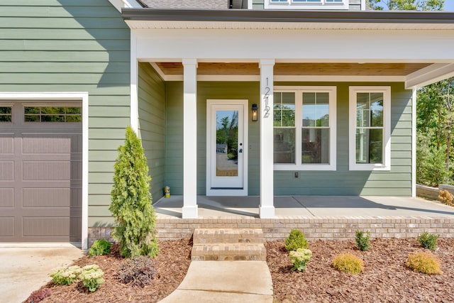 entrance to property featuring covered porch and a garage