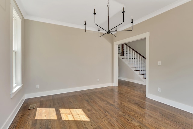 unfurnished dining area featuring crown molding, a chandelier, and dark wood-type flooring