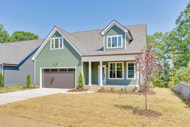 cape cod home with a front lawn, covered porch, and a garage