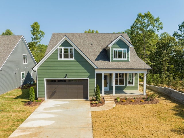 view of front of property featuring a front yard, a porch, and a garage